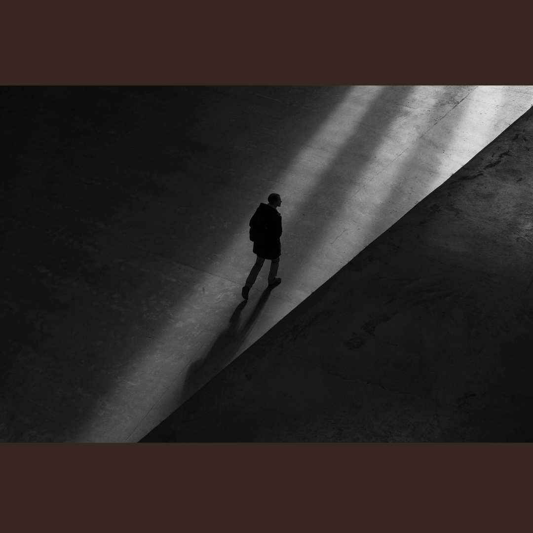 photo of man walking in shadows